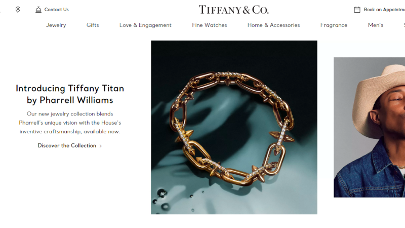 Screenshot of Tiffany & Co. website homepage featuring a banner for the new jewelry collection "Tiffany Titan" designed by Pharrell Williams. Text also includes links to shop for jewelry, gifts, watches, and more.