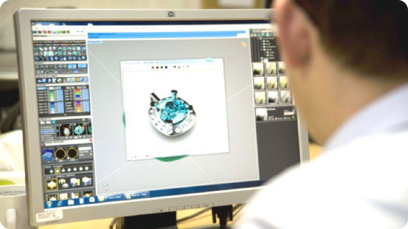 Person using 3D design software on a computer to create a gemstone ring.