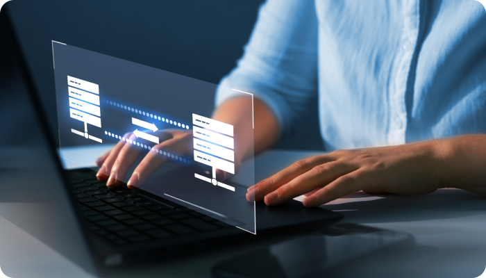 The person is wearing a light blue shirt, and the focus is on their hands typing on the keyboard.