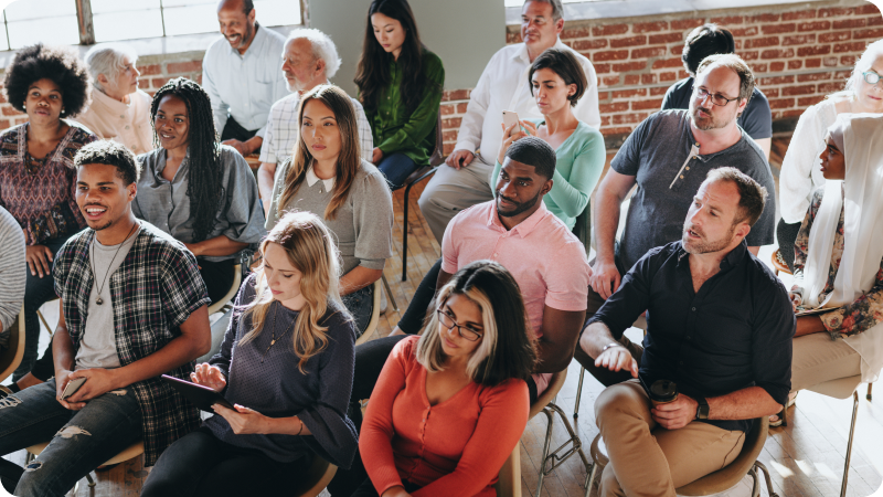 Diverse group of people sitting and attentively listening during a seminar or presentation.